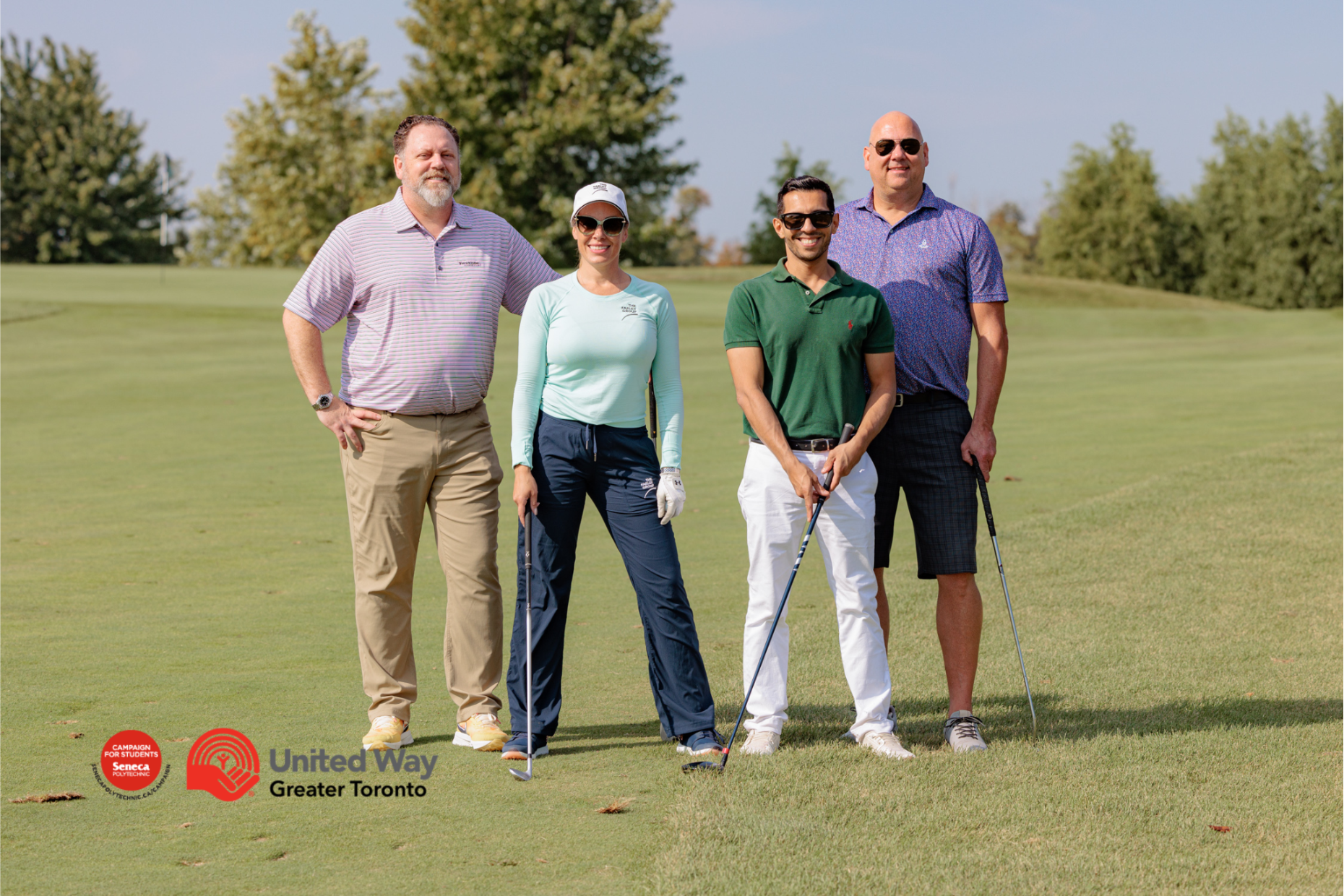 Four members of The Farley Group staff posing with golf clubs at the annual Seneca College charity golf tournament.