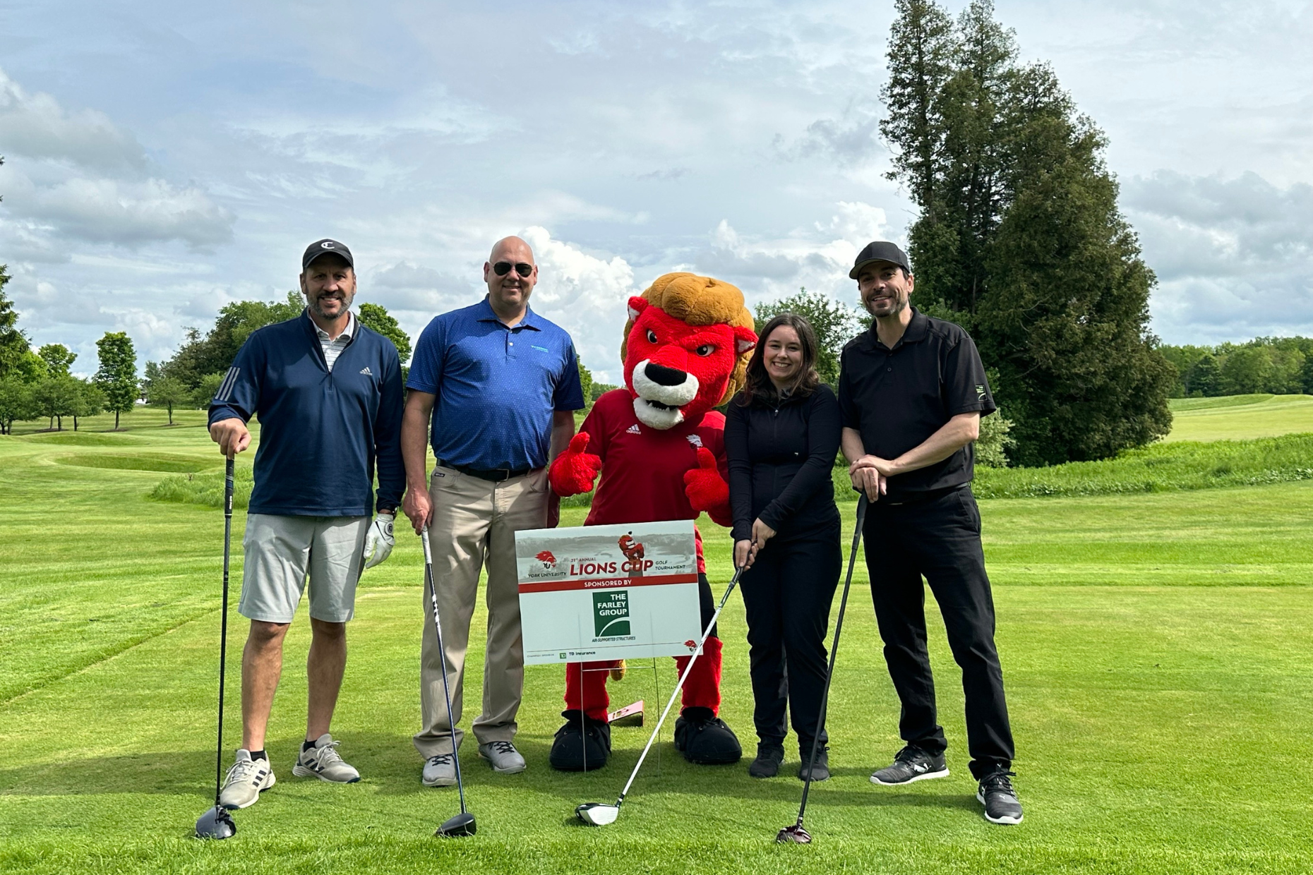 The Farley Group team members posing with a lion mascot during the annual Lions Cup Golf Tournament for York University.